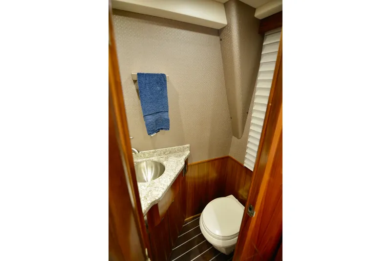 Slide: The Image of 2019 Viking 68 Convertible yacht bathroom with marble countertop and wooden accents. - 5