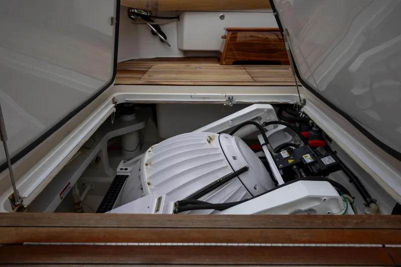 Slide: The Image of Engine compartment of 2019 Viking 68 Convertible yacht, showcasing mechanical components and wooden deck. - 57