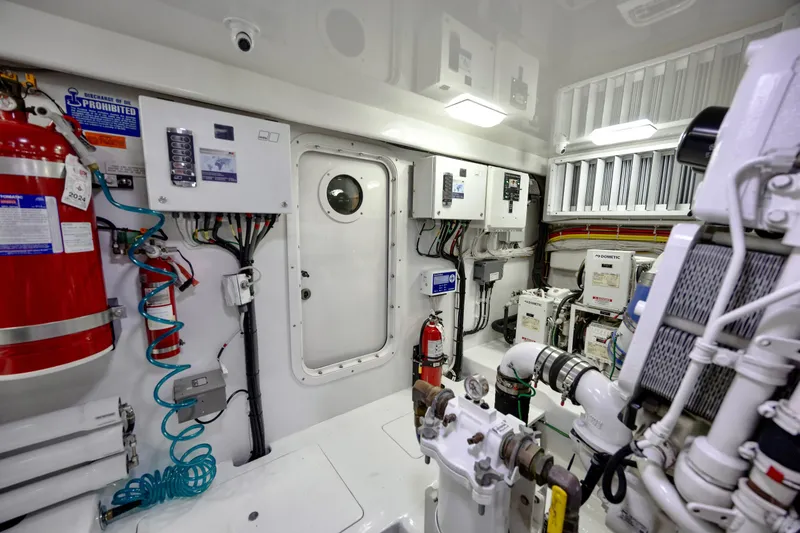 Slide: The Image of Engine room of 2019 Viking 68 Convertible yacht, featuring equipment and safety systems. - 63