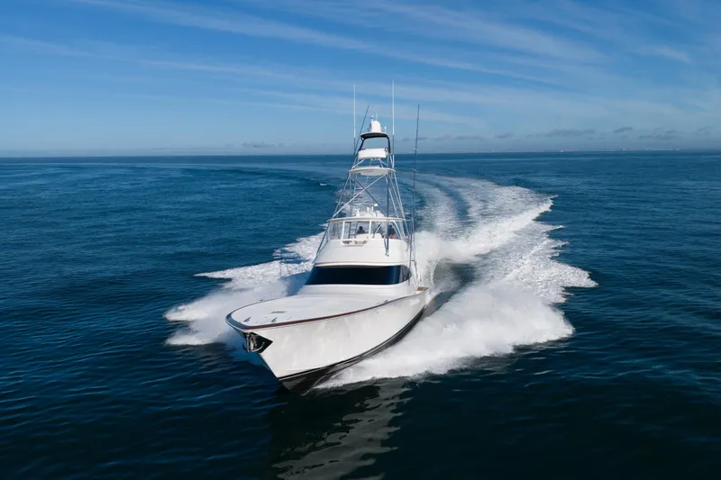 Slide: The Image of 2019 Viking 68 Convertible yacht cruising on open ocean under clear blue sky. - 72