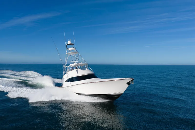 Slide: The Image of 2019 Viking 68 Convertible yacht cruising on open ocean under clear blue sky. - 73