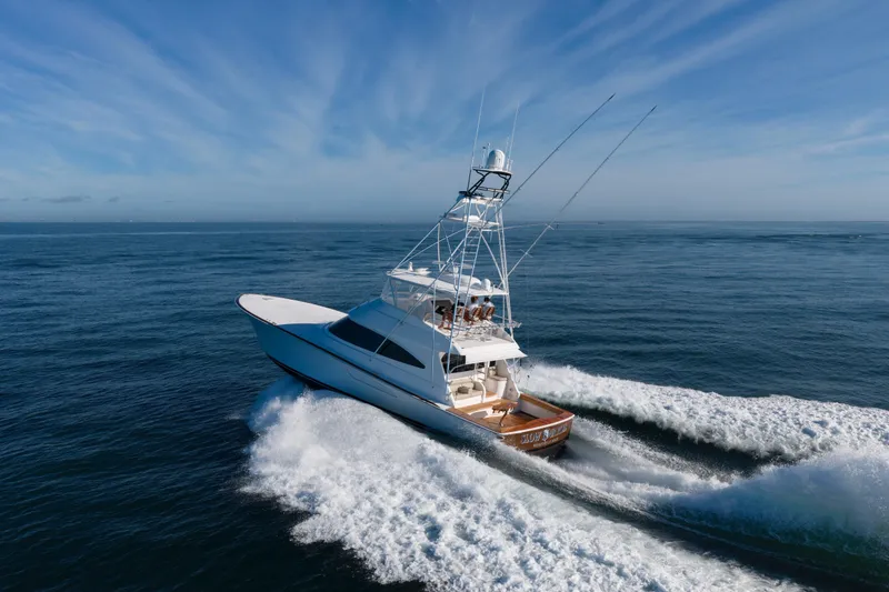 Slide: The Image of 2019 Viking 68 Convertible yacht cruising on open ocean under clear blue sky. - 74