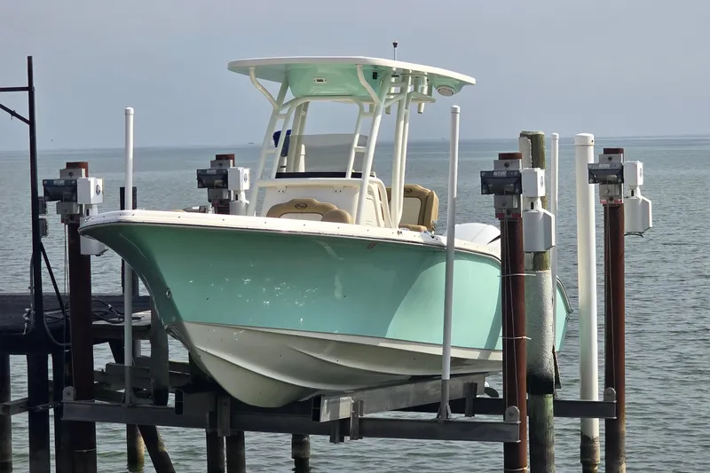 Slide: The Image of 2020 Key West 239 FS boat on lift by the water. - 2