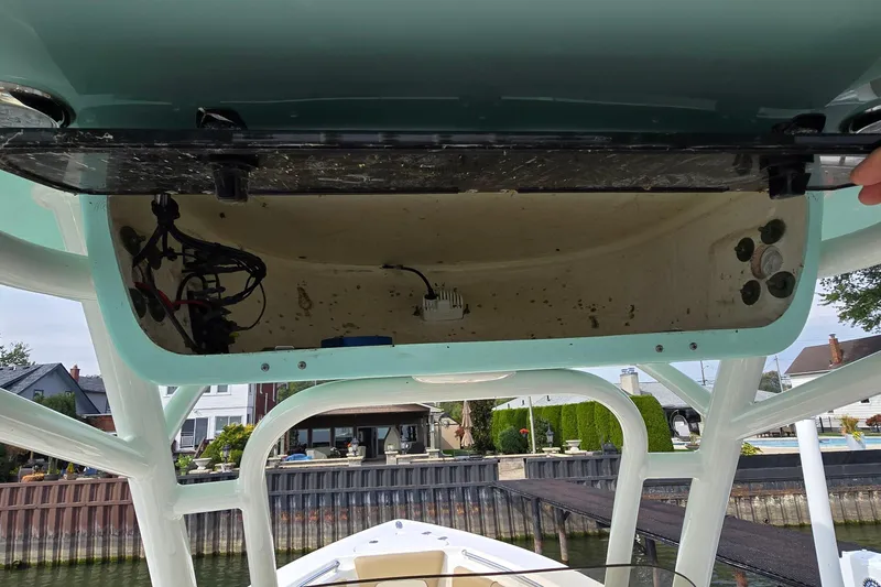 Slide: The Image of 2020 Key West 239 FS boat storage compartment, open with visible wiring and components. - 28