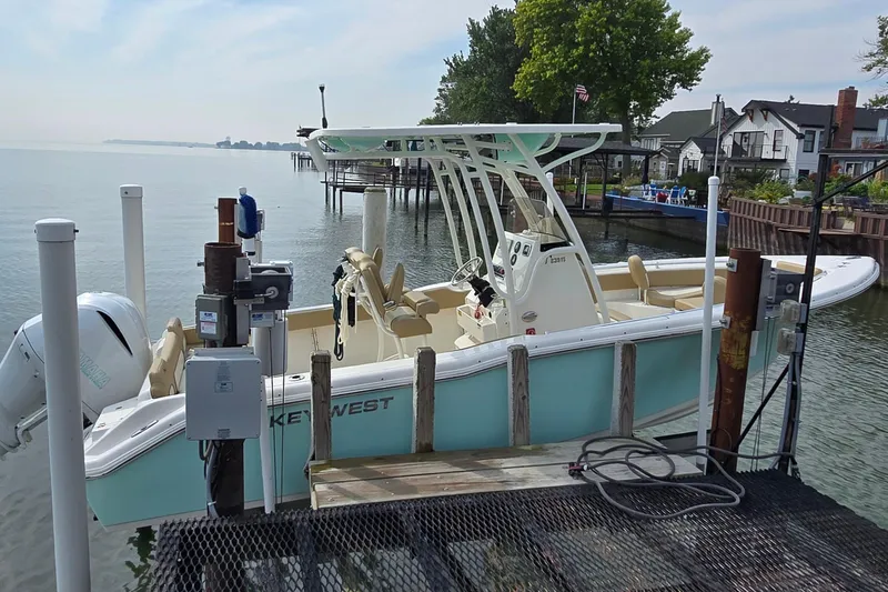 Slide: The Image of 2020 Key West 239 FS boat docked by waterfront homes, featuring a sleek design and modern amenities. - 3