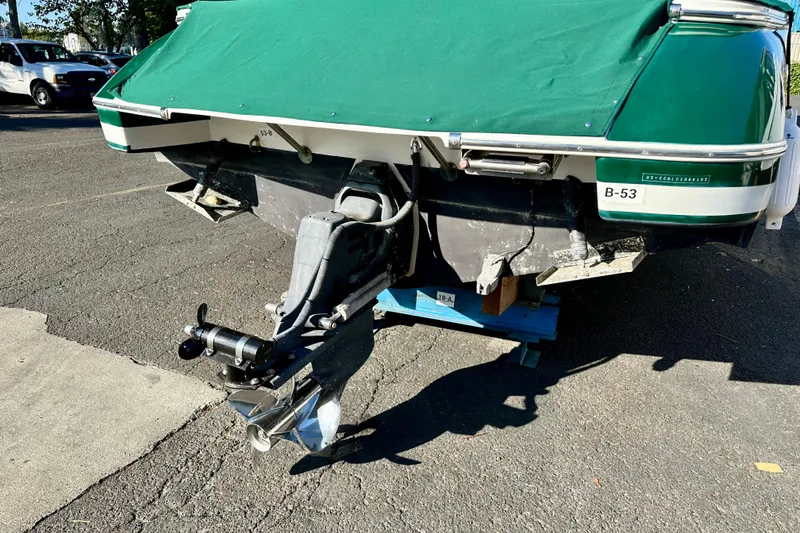 Slide: The Image of 2002 Chris-Craft Launch 28 boat with green cover, parked on asphalt. - 12