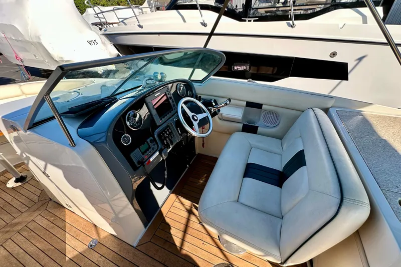 Slide: The Image of 2002 Chris-Craft Launch 28 boat interior with steering wheel and seating on wooden deck. - 17