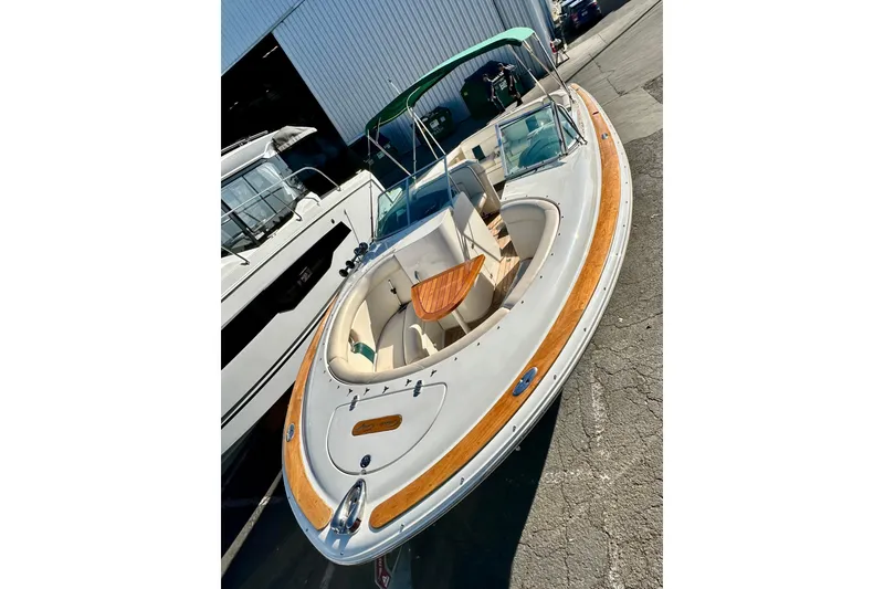 Slide: The Image of 2002 Chris-Craft Launch 28 boat with wooden accents, docked near a warehouse. - 37