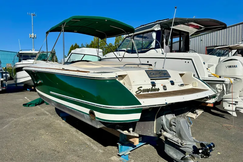 Slide: The Image of 2002 Chris-Craft Launch 28 boat with green hull, docked outdoors under clear blue sky. - 40