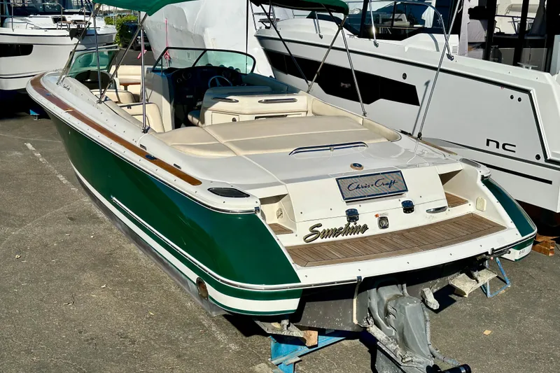 Slide: The Image of 2002 Chris-Craft Launch 28 boat with green and white exterior, docked at a marina. - 41