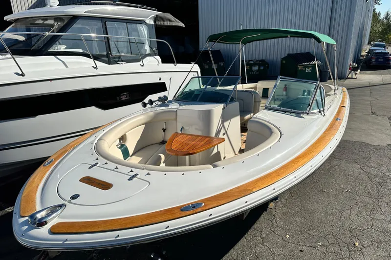 Slide: The Image of 2002 Chris-Craft Launch 28 boat with wooden accents and green canopy, docked outdoors. - 6