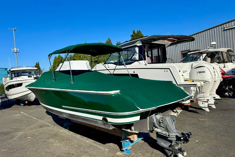 Slide: The Image of 2002 Chris-Craft Launch 28 boat with green cover, parked in a marina. - 8
