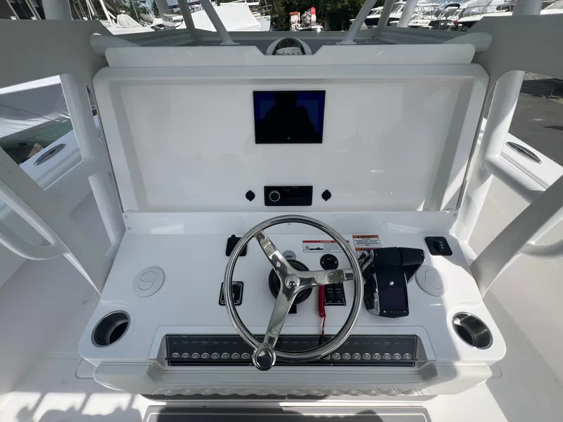 Slide: The Image of 2024 Invincible 39 Open Fisherman helm with steering wheel and electronic controls. - 7