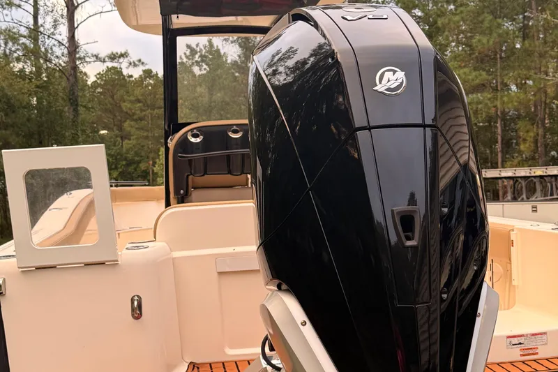 Slide: The Image of 2021 Scout 235 XSF boat with powerful outboard motor, set against a forest backdrop. - 2