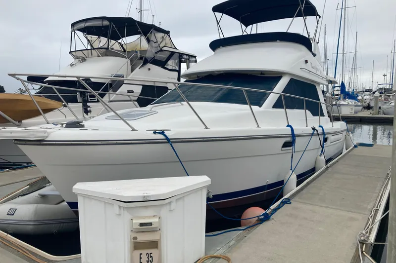 Slide: The Image of 1999 Bayliner 3388 Command Bridge Motoryacht docked at marina, side view. - 1