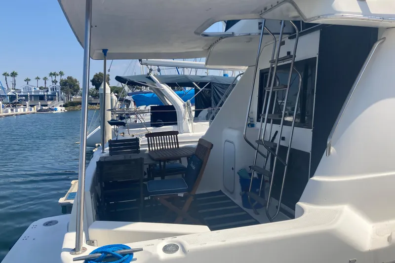 Slide: The Image of 1999 Bayliner 3388 Command Bridge Motoryacht docked at marina, featuring outdoor seating. - 12