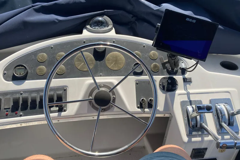 Slide: The Image of 1999 Bayliner 3388 Command Bridge Motoryacht helm with steering wheel and navigation instruments. - 23