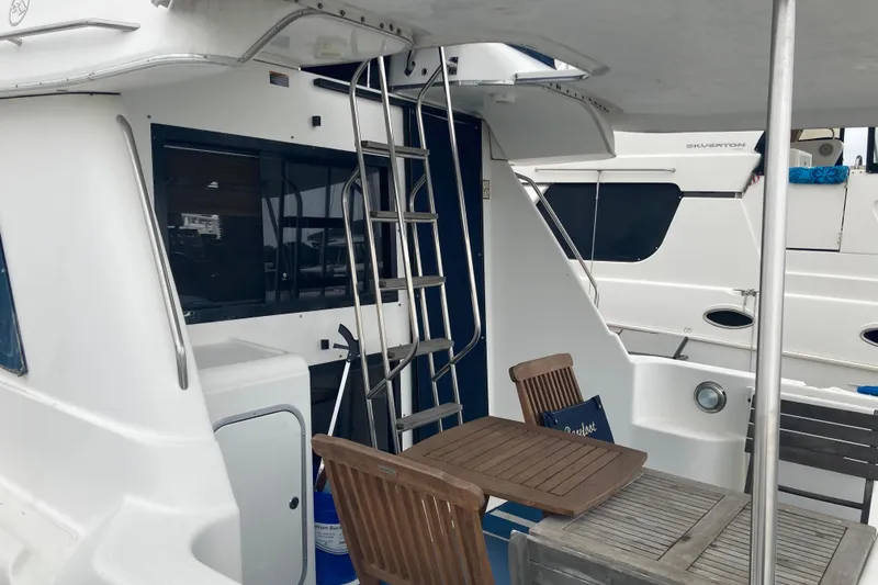 Slide: The Image of 1999 Bayliner 3388 Command Bridge Motoryacht with outdoor seating and ladder. - 3