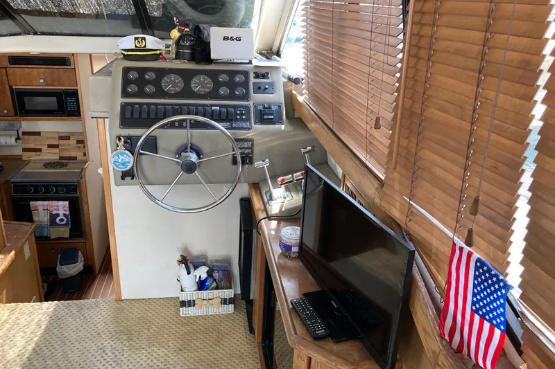 Slide: The Image of 1999 Bayliner 3388 Command Bridge Motoryacht interior with helm, kitchen, and American flag. - 30