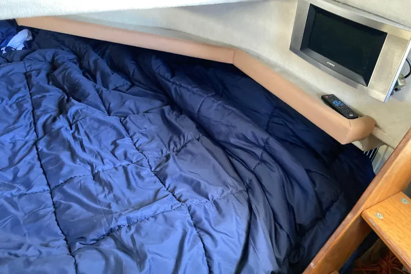 Slide: The Image of Cozy cabin interior of 1999 Bayliner 3388 Command Bridge Motoryacht with blue bedding and TV. - 43