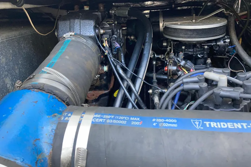 Slide: The Image of Engine compartment of a 1999 Bayliner 3388 Command Bridge Motoryacht, featuring hoses and components. - 53