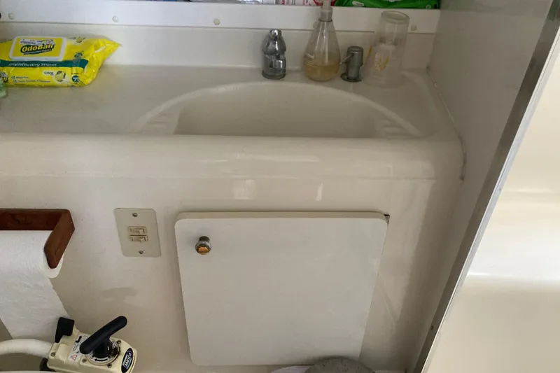 Slide: The Image of 1999 Bayliner 3388 Command Bridge Motoryacht bathroom sink with cleaning supplies. - 8