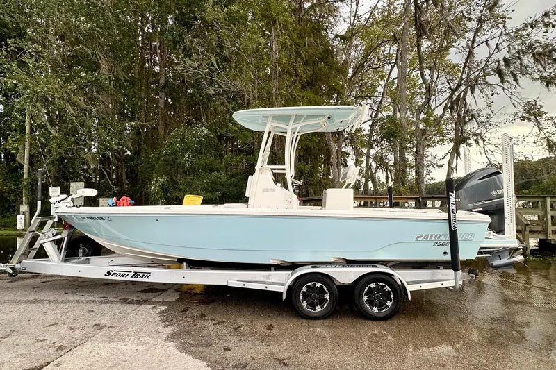 The Image of 2019 Pathfinder 2500 Hybrid boat on trailer, parked outdoors near trees. - 1