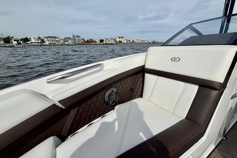 Slide: The Image of 2024 Cobalt R4 Outboard boat interior with luxurious seating, cruising on a scenic waterfront. - 16