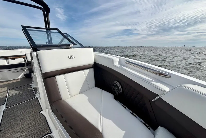 Slide: The Image of 2024 Cobalt R4 Outboard boat interior with luxurious seating, overlooking calm waters. - 17