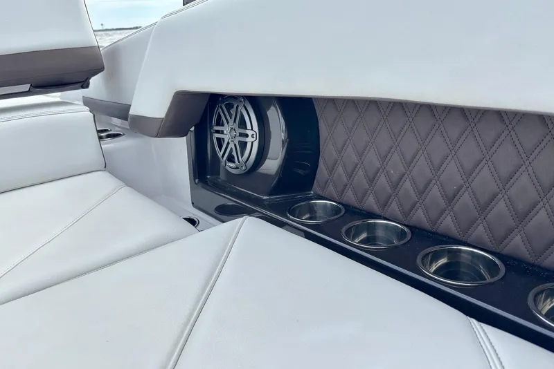 Slide: The Image of 2024 Cobalt R4 Outboard interior with speaker, quilted panel, and cup holders. - 19