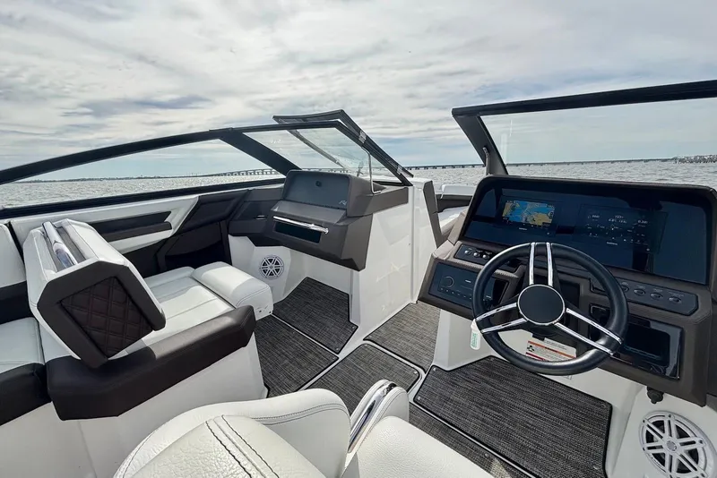 Slide: The Image of 2024 Cobalt R4 Outboard boat interior with modern dashboard and steering wheel, overlooking the water. - 7