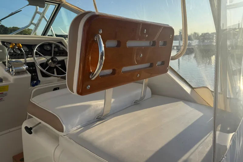 Slide: The Image of 1997 Wellcraft 3300 Coastal boat interior with steering wheel and wooden seat back. - 10