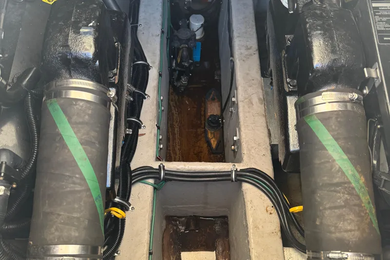 Slide: The Image of Engine compartment of a 1997 Wellcraft 3300 Coastal boat, showing dual engines and hoses. - 16