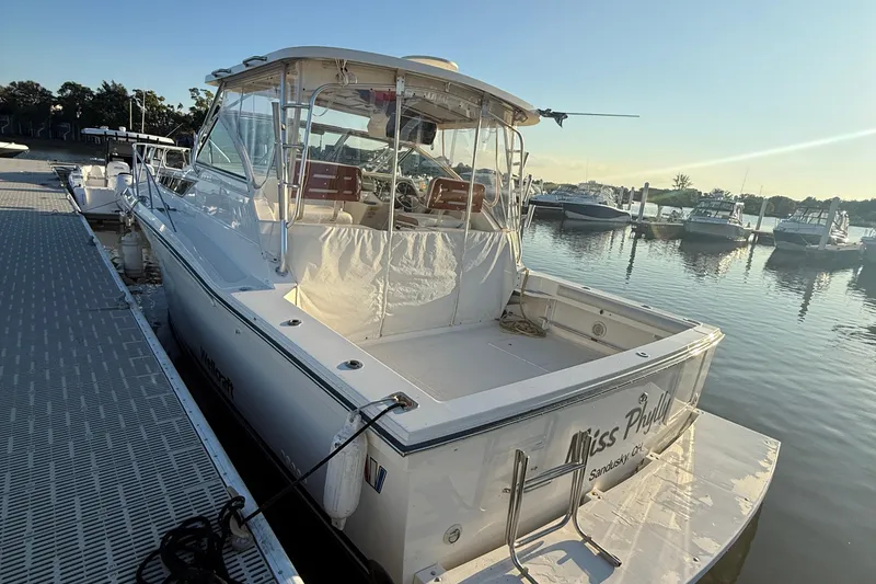Slide: The Image of 1997 Wellcraft 3300 Coastal boat docked at marina, sunny day, calm water. - 5