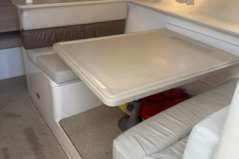 Slide: The Image of 1997 Wellcraft 3300 Coastal cabin interior with dining table and cushioned seating. - 8
