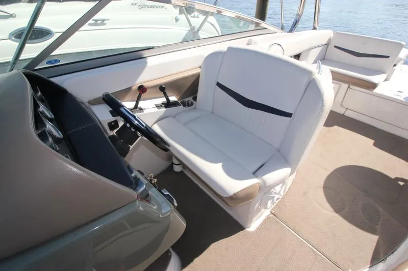Slide: The Image of 2008 Four Winns 310 Horizon boat interior with white seating and steering console. - 14
