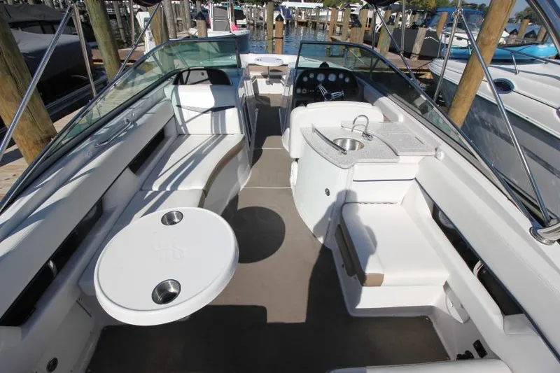 Slide: The Image of 2008 Four Winns 310 Horizon boat interior with seating, table, and sink at a marina. - 4