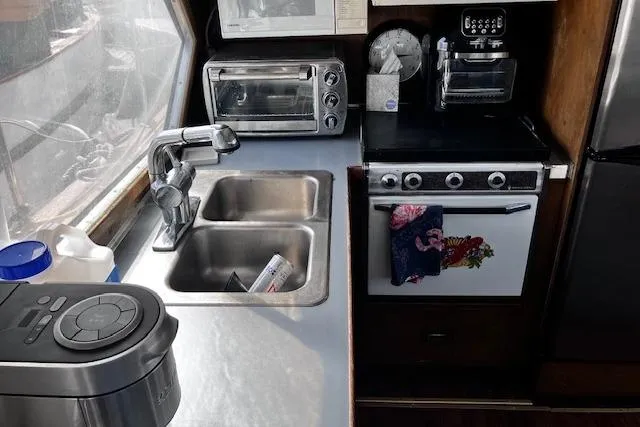 Slide: The Image of 1973 Tollycraft 40' Aft Cabin kitchen with sink, stove, and appliances. - 15