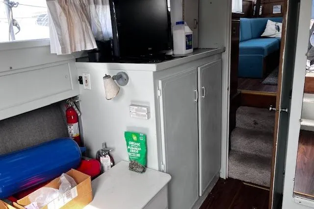 Slide: The Image of 1973 Tollycraft 40' Aft Cabin interior with cabinets, TV, and seating area. - 17