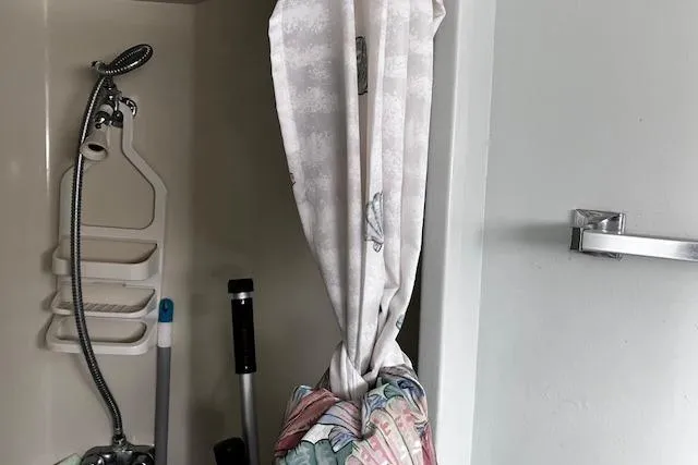 Slide: The Image of 1973 Tollycraft 40' Aft Cabin shower area with curtain and cleaning tools. - 18