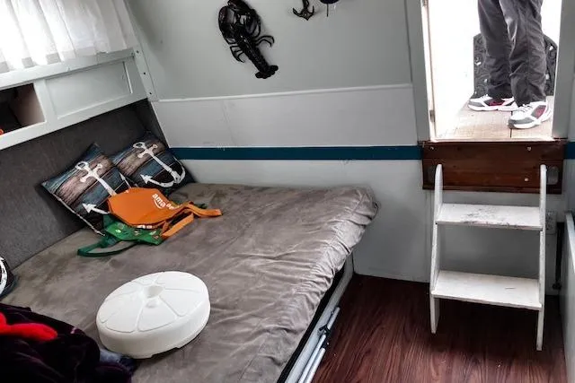 Slide: The Image of 1973 Tollycraft 40' Aft Cabin interior with bed, nautical decor, and wooden steps. - 20