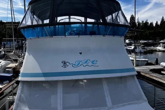 Slide: The Image of 1973 Tollycraft 40' Aft Cabin boat docked at a marina, featuring blue accents. - 3