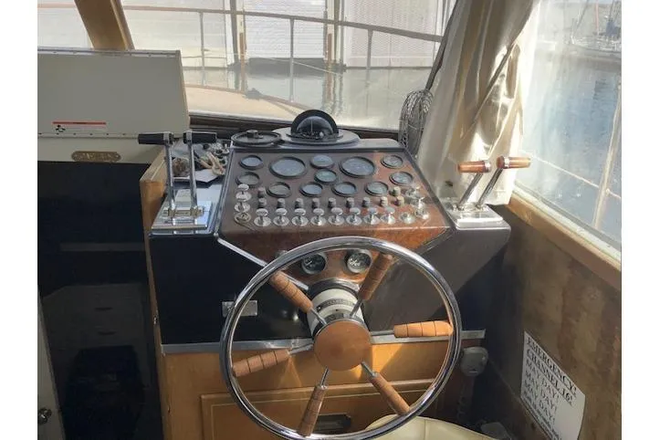 Slide: The Image of 1973 Tollycraft 40' Aft Cabin helm with vintage steering wheel and control panel. - 11