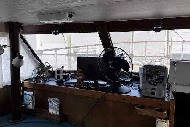 Slide: The Image of 1973 Tollycraft 40' Aft Cabin interior with fans, monitor, and nautical decor. - 13