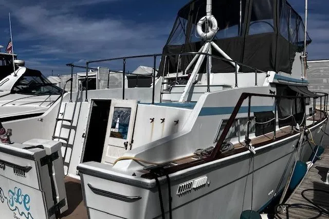 Slide: The Image of 1973 Tollycraft 40' Aft Cabin boat docked at marina under clear sky. - 2