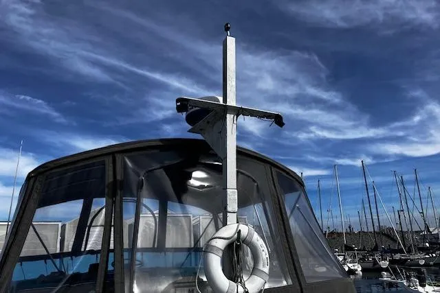 Slide: The Image of 1973 Tollycraft 40' Aft Cabin boat with life preserver, docked under a blue sky. - 4