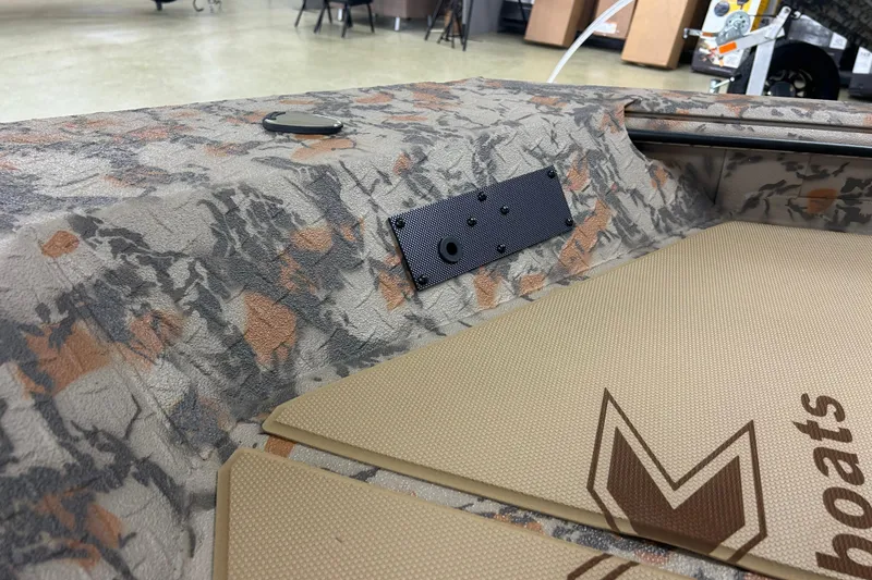 Slide: The Image of Camouflage interior of 2026 Xpress HD16DB boat with textured flooring and logo. - 3