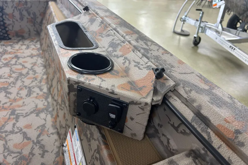 Slide: The Image of 2026 Xpress HD16DB boat interior with camo design, cup holders, and control panel. - 6