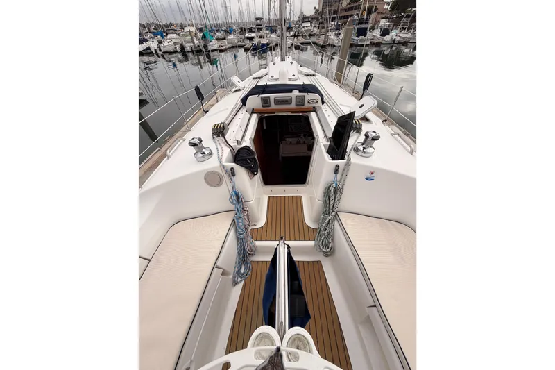 Slide: The Image of 2009 Hunter 38 sailboat cockpit with marina view, featuring clean deck and ropes. - 17