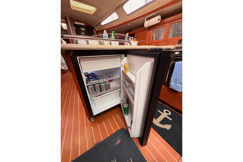 Slide: The Image of Open mini fridge in 2009 Hunter 38 yacht interior, showcasing beverages and snacks. - 23